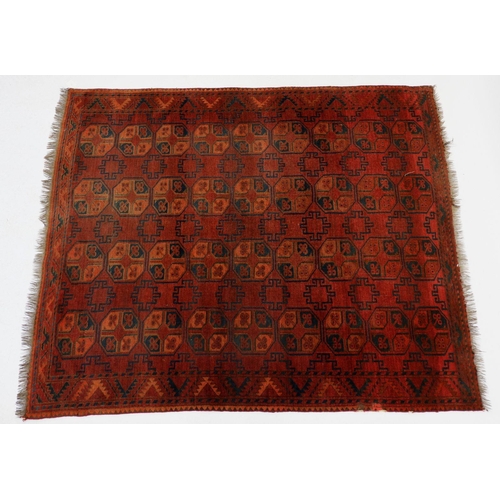 1033 - A Turkoman style rug with four rows of hexagonal guls on a madder ground, 186 x 152cm