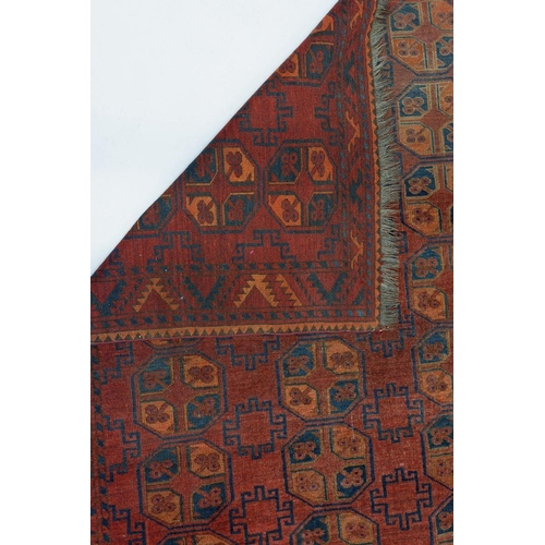 1033 - A Turkoman style rug with four rows of hexagonal guls on a madder ground, 186 x 152cm