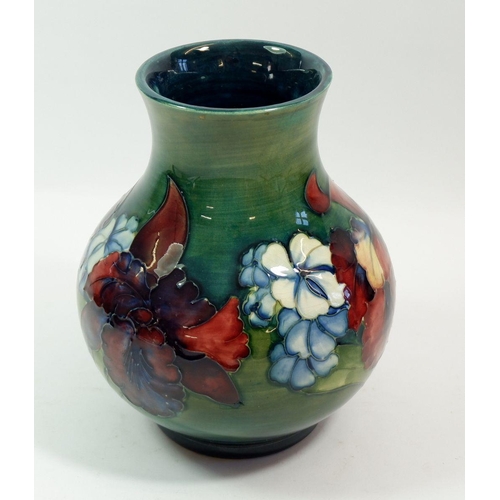 118 - A Moorcroft large Orchid vase on a green ground with Queen Mary paper label, 20cm tall