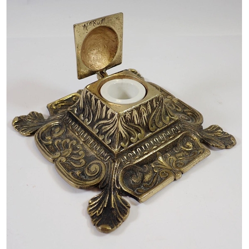 632 - A brass foliate caste inkwell and a brass jotter