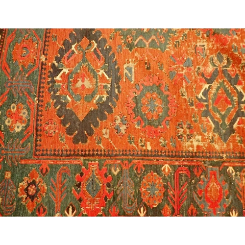 1019 - A Turkoman antique rug with geometric motifs on a madder ground with blue geometric border, worn 332... 