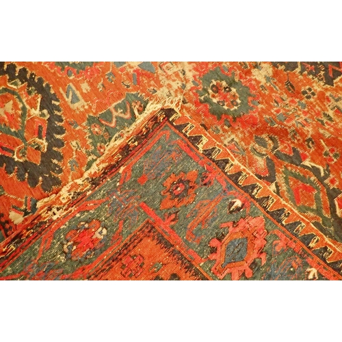 1019 - A Turkoman antique rug with geometric motifs on a madder ground with blue geometric border, worn 332... 