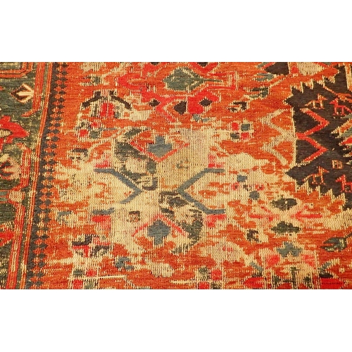 1019 - A Turkoman antique rug with geometric motifs on a madder ground with blue geometric border, worn 332... 