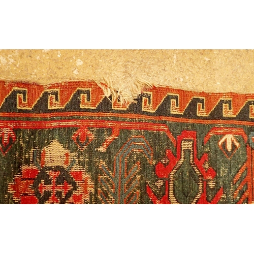 1019 - A Turkoman antique rug with geometric motifs on a madder ground with blue geometric border, worn 332... 