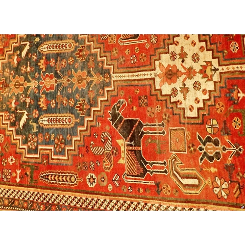 1021 - A Persian antique rug with central blue medallion surrounded by horses and other animals and flowers... 