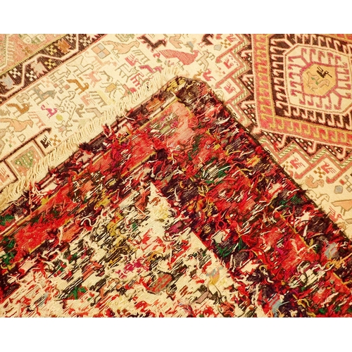 1043 - A Turkish rug with cream ground decorated animals and two lozenges, 210 x 120cm