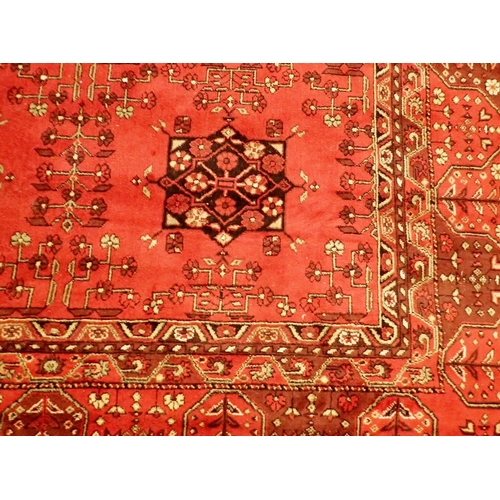 1044 - A Kashmir Afghan design rug with rusty red ground, 230 x 160cm