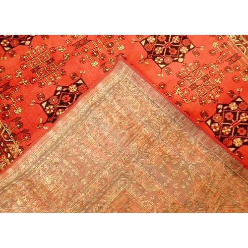 1044 - A Kashmir Afghan design rug with rusty red ground, 230 x 160cm