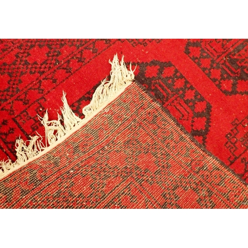 1096 - A Turkoman red wool rug with two blue guls 124 x 80cm