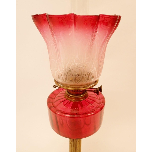 1317 - A Victorian brass oil lamp on black base and with frilled and etched cranberry glass shade, 67cm