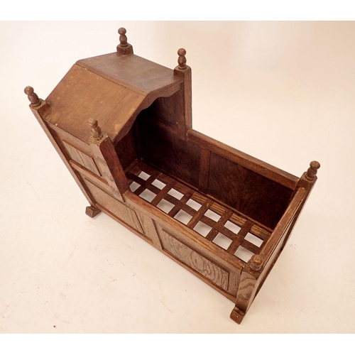 1355 - An early 20th century oak panelled rocking dolls crib, 47cm long