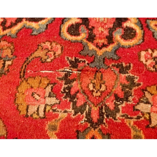 1360 - A large Persian Sarouk carpet with red ground and traditional floral pattern - repaired, 291 x 206cm... 