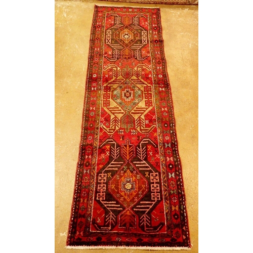 1395 - A Perian Heriz runner with rich red ground and unique medallion pattern 310 x 98cm