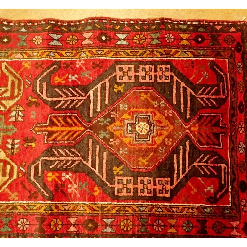 1395 - A Perian Heriz runner with rich red ground and unique medallion pattern 310 x 98cm