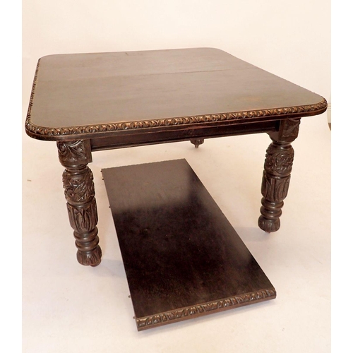 1402 - A large Victorian stained oak wind out dining table with one interleaf, with carved border and carve... 