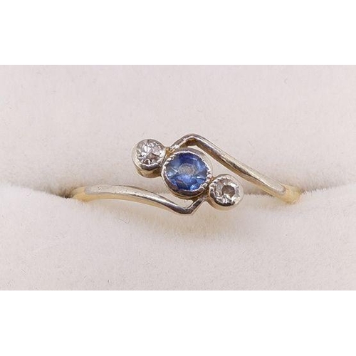 448 - A 9 carat gold crossover ring set blue stone flanked by two diamonds, size P 2.5g