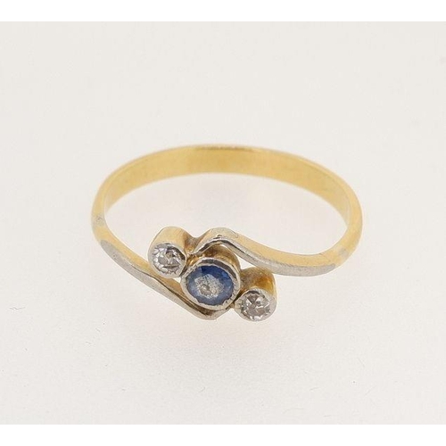 448 - A 9 carat gold crossover ring set blue stone flanked by two diamonds, size P 2.5g