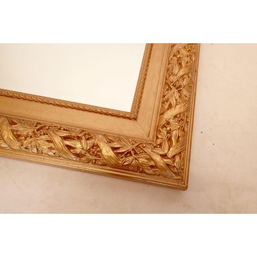 989 - A large gilt framed mirror with mistletoe decoration, 80 x 110cm