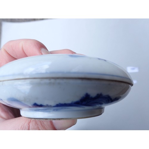 164 - A Chinese blue and white traditional ink paste circular box decorated landscape motifs to top and ba... 