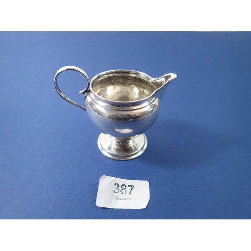 387 - An Arts & Crafts silver hammered cream jug, Birmingham 1909 by Liberty & Co. 46g, 7.5cm