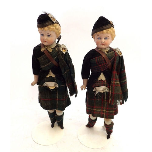 1103 - A pair of bisque porcelain dolls in Scottish costumes, 27cm tall