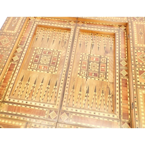 1209 - A Damascus marquetry fold top games table with card baize, backgammon and chess boards