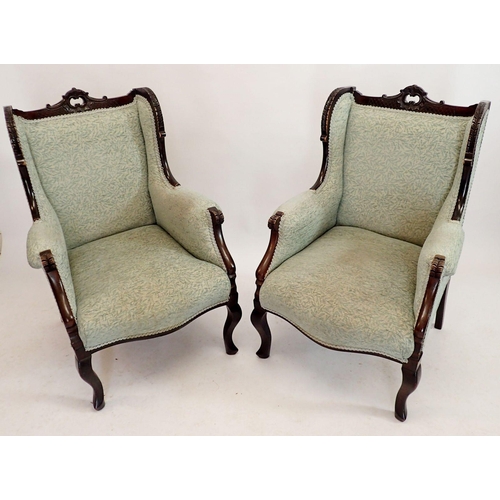 1249 - A pair of Victorian mahogany framed wing armchairs with carved rococo style decoration