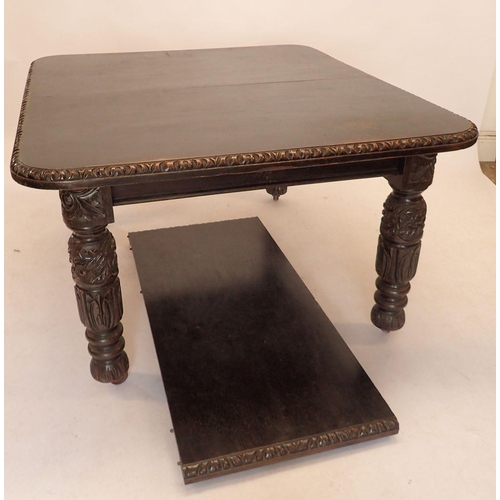 1291 - A large Victorian stained oak wind out dining table with one interleaf, with carved border and carve... 