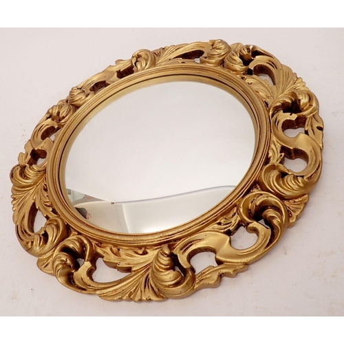 1293 - A gilt plaster convex mirror with scroll decoration, 50cm diameter