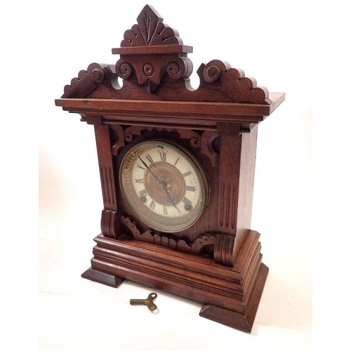 735 - An American 19th century oak carved mantel clock with enamel chapter ring and carved case, 38cm tall