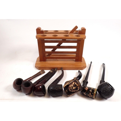 804 - A wooden pipe stand with seven vintage pipes