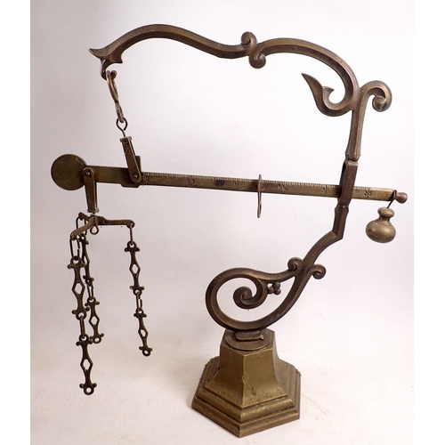 842 - A brass sack scale on scrollwork wall bracket