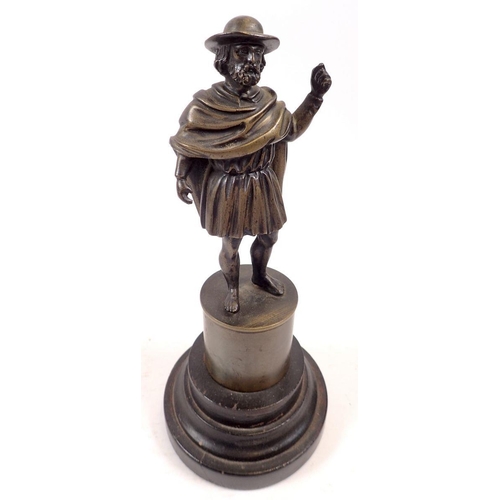 861 - A cast bronze figure of man in hat and tunic on pedestal and wooden base, 19cm tall