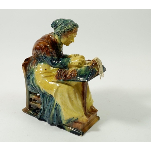 99 - A 19th century pottery figure of a lace maker seated with her bobbins, 21cm tall