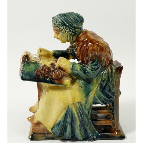 99 - A 19th century pottery figure of a lace maker seated with her bobbins, 21cm tall