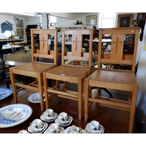 1093 - A set of three oak chapel chairs with crucifix to back and prayer book pockets