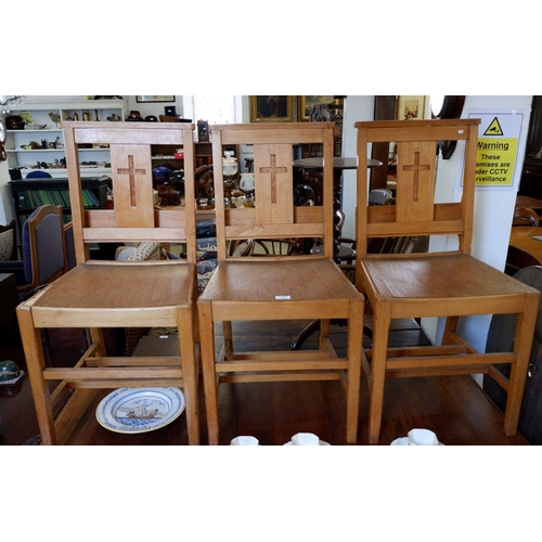 1093 - A set of three oak chapel chairs with crucifix to back and prayer book pockets