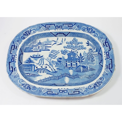 49 - An antique blue and white Staffordshire Stone China willow pattern meat plate, 44.5cm long