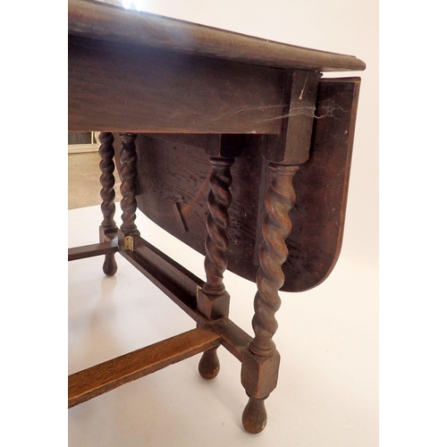 1186 - An oak drop-leaf dining table with carved border and spiral turned supports