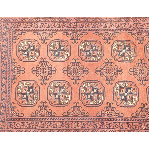 1192 - A Turkoman style runner with two rows of guls on madder ground, 289 x 87cm