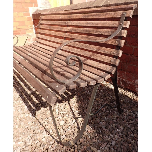 1199 - A garden bench with slatted wooden seat and scrolled cast iron ends, 153cm wide