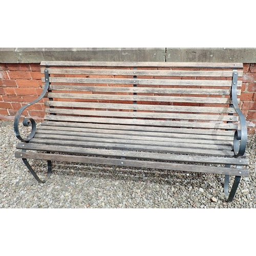 1199 - A garden bench with slatted wooden seat and scrolled cast iron ends, 153cm wide