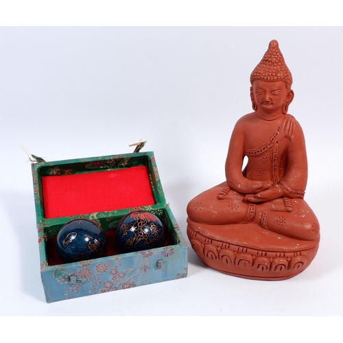 64 - A seated terracotta Buddha, 19cm tall and a pair of Chinese Baoding balls boxed (2)