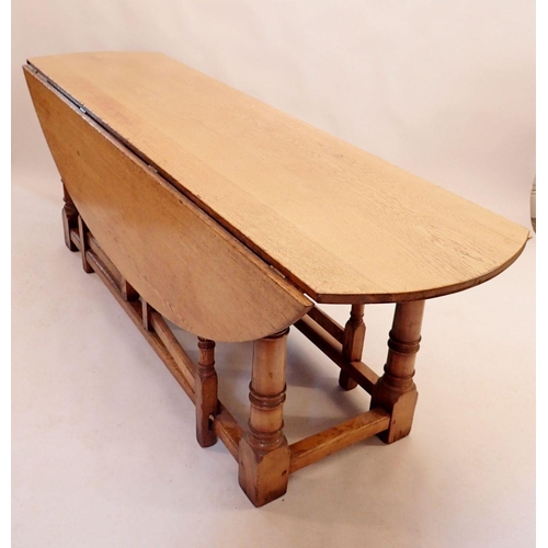 1128 - A good quality large Brynhall oak dropleaf oval dining table on turned column supports 226x145x76cm