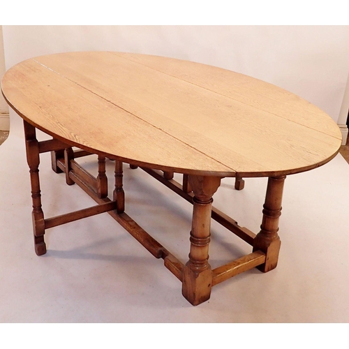 1128 - A good quality large Brynhall oak dropleaf oval dining table on turned column supports 226x145x76cm