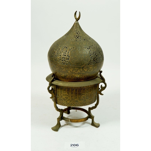 206 - An Islamic pierced and engraved brass incense burner on three pad feet, 24cm tall