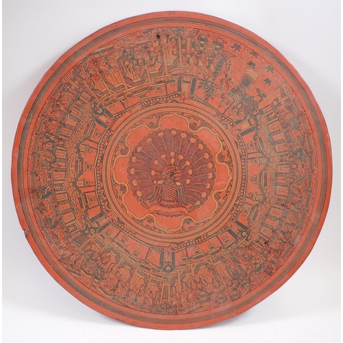 217 - An Oriental circular red lacquer papier mache panel decorated with peacock and immortals, 46cm diame... 