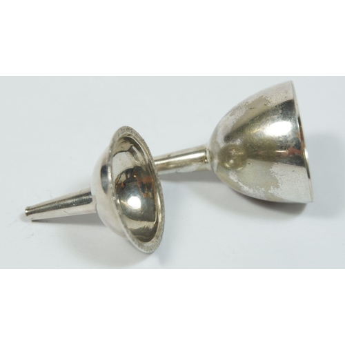 271 - Two silver plated miniature wine funnels and a white metal part eastern cruet set