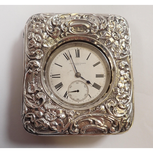 563 - An Edwardian silver embossed pocket watch holder, Birmingham 1909 and a silver watch 'The Faringdon'... 