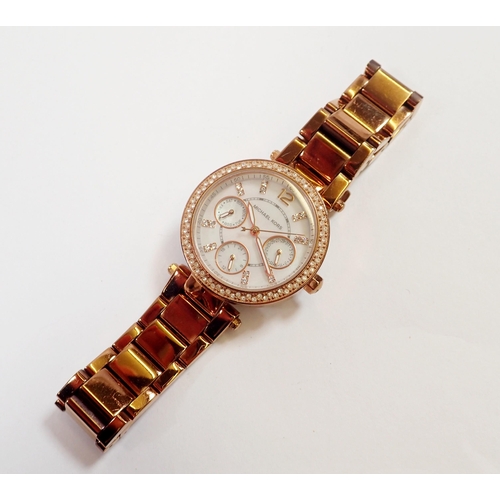 571 - A Michael Kors ladies rose gold plated watch with calendar dial and diamonte rim